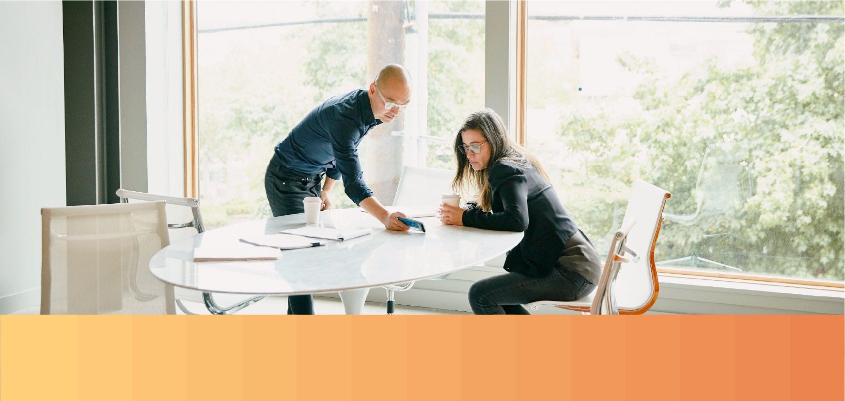 Man shows his female colleague a website on his mobile phone